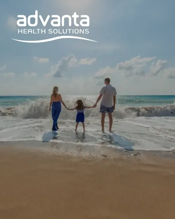 Advanta Health Solutions logo over a family walking along the beach