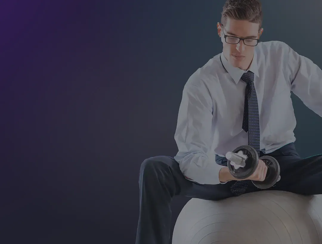 Office worker lifting a dumbbell while sitting on an exercise ball