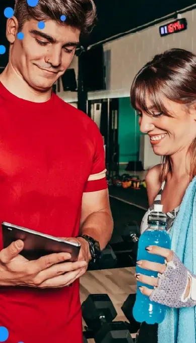 Two people in a gym looking at a phone together