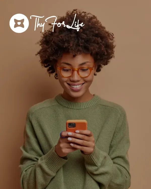 ThyForLife logo over a woman smiling at her phone