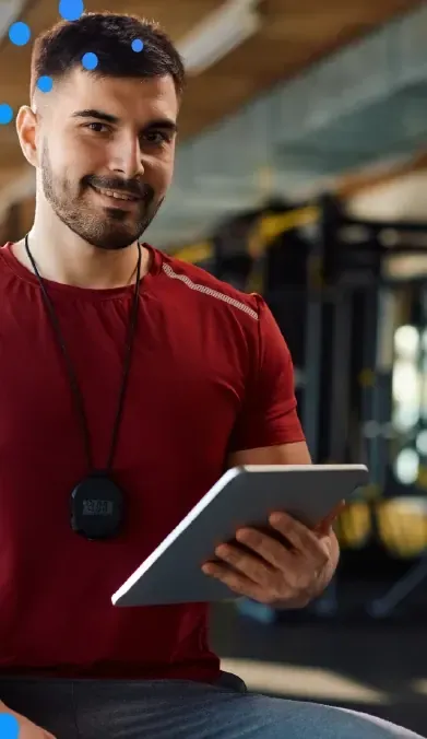 Trainer reviewing client data on a tablet in a gym